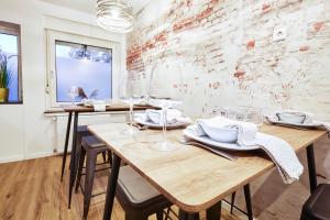 comedor con mesas de madera y pared de ladrillo en nobilis Apartment - 8 Pers. - Zentrumsnah - Netflix, en Meppen