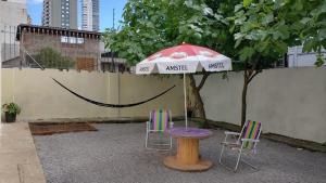 einen Tisch und zwei Stühle unter einem Schirm in der Unterkunft Casarão 2 in Caxias do Sul