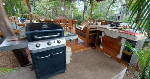an outdoor kitchen with a grill and a table at Rancho Almendras at Hacienda Nosara in Nosara