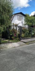ein weißes Haus mit einem Zaun davor in der Unterkunft Casa Villa Amanecer in Villarrica