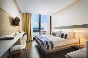 a hotel room with a bed and a desk with a window at Hotel Admiral - Liburnia in Opatija