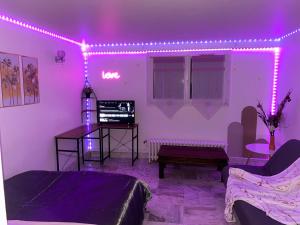 een woonkamer met paarse verlichting aan de muur bij Nice Studio Livry in Livry-Gargan