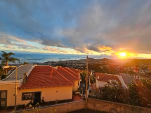 una puesta de sol sobre una ciudad con casas y el océano en Casa de Feria do Livramento en Funchal