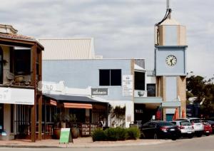 a building with a clock tower in the middle of a street at Balcombe Retreat in Mount Martha