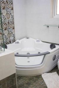 a white bath tub in a bathroom with a window at 4bedroom westlands raphta Nairobi in Nairobi