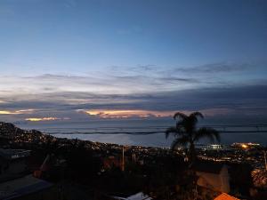 a view of the ocean and a city at night at Casa de Feria do Livramento in Funchal