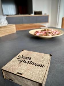 a sign on a counter with a plate of pizza at South Apartmani in Vranje