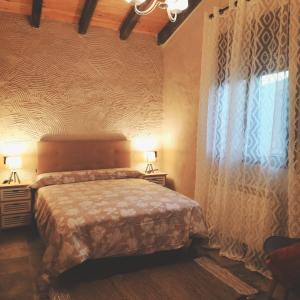 um quarto com uma cama e duas mesas de cabeceira e uma janela em Villa pose em Robledillo