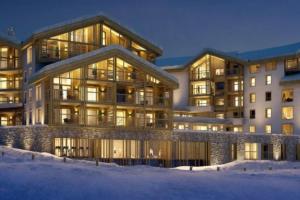 ein Apartmenthaus im Schnee in der Nacht in der Unterkunft La Terrasse de l Alpe d Huez in L'Alpe-d'Huez