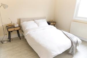 a bedroom with a large white bed with two night stands at Central London Flat, Stylish 1BR near Shoreditch in London