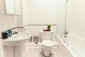 a white bathroom with a toilet and a sink at Central London Flat, Stylish 1BR near Shoreditch in London