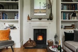 a living room with a fireplace and a couch at Devon Farmhouse in Kingsbridge