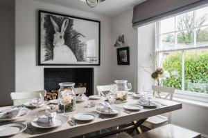 a dining room with a table with a rabbit on the wall at Devon Farmhouse in Kingsbridge