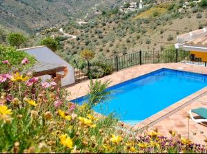 una gran piscina en un jardín con flores en Casa Nobleza, en Málaga