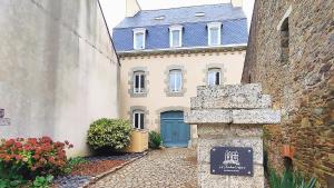 uma casa com uma porta azul e um edifício em Les Chambres D'Hespéris em Pleyben