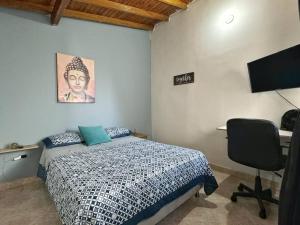 Schlafzimmer mit einem Bett, einem Schreibtisch und einem Monitor in der Unterkunft Apartamento con Terraza Estadio in Medellín