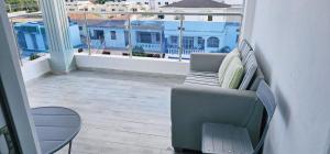 uma varanda com um sofá e uma cadeira num pátio em Casa familiar em San Pedro de Macorís