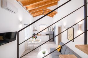 un soggiorno e una cucina con pareti bianche e soffitti in legno. di Windrose Apartments - Shared Pool a Ipsos