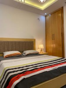 - une chambre avec un grand lit et une armoire en bois dans l'établissement Dar sammoud S+1, à Kelibia