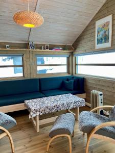 a living room with a blue couch and chairs at Hito - cabin between Flå and Eggedal in Flå