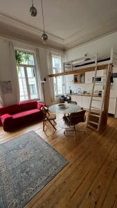 uma sala de estar com um sofá vermelho e uma cama alta em Arti Appart Louise/Flagey/Centre em Bruxelas