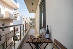 een balkon met een tafel met wijnflessen en glazen bij Nomada Chania 2 in Chania