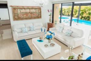 een woonkamer met twee witte banken en een tafel bij Luxury Mocawa House: Two Jacuzzis, Pool & BBQ. in La Tebaida