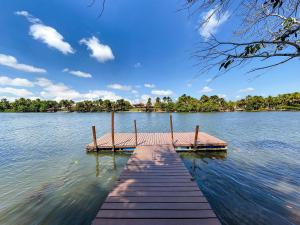 a dock in the middle of a lake at Condomínio Lençóis Ville Residence in Barreirinhas