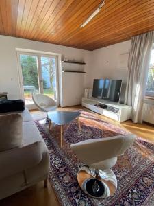 a living room with a couch and a tv at Großzügige Ferienwohnung mit Terrasse und Garten in Inzell