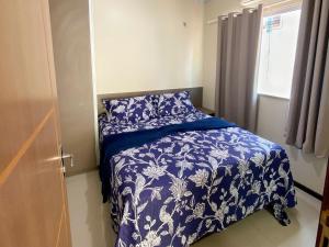 a bedroom with a blue and white bed and a window at Condomínio Lençóis Ville Residence in Barreirinhas +32 photos