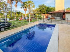 a swimming pool with a playground in the background at Condomínio Lençóis Ville Residence in Barreirinhas