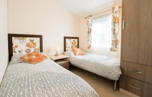 a bedroom with two beds and a window at Little Eden Country Park, Bridlington with Private Hot Tubs in Bridlington