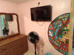 a room with a fan and a flat screen tv at Hospedaje Barato Mi Casita de Colores in Tijuana