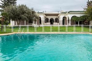 a swimming pool in front of a house at Arabesque House in La Marsa