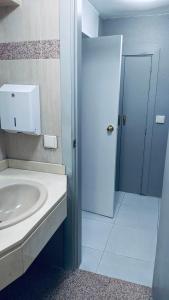 a white bathroom with a sink and a door at Hostel 165 in Madrid