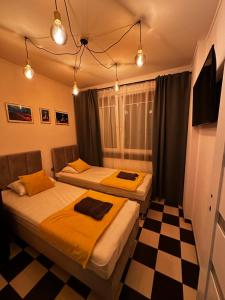 two beds in a room with a checkered floor at Apartament 70’s in Kołobrzeg
