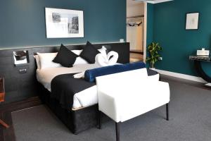 a bedroom with a bed with black and white pillows at The Kings Arms Hotel in Berwick-Upon-Tweed