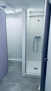 a bathroom with a shower with a glass door at Hostel 165 in Madrid
