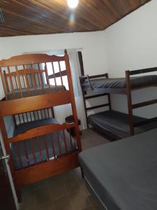 Cette chambre comprend 2 lits superposés et une table. dans l'établissement Chácara Recanto do Sol, à Mogi das Cruzes