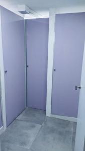 two doors in an empty room with purple walls at Hostel 165 in Madrid