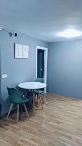 een kamer met een tafel en stoelen en een blauwe muur bij Hostel 165 in Madrid