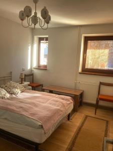 a bedroom with a bed and a table and a window at U starkych in Poprad