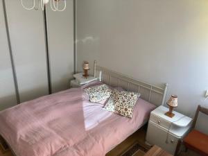 um quarto com uma cama cor-de-rosa com duas mesas-de-cabeceira em U starkych em Poprad