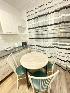 a kitchen with a table and chairs in a kitchen at ЖК Отау in Almaty