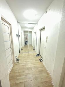 a person standing in a hallway with shoes on the floor at ЖК Отау in Almaty