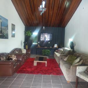 a living room with leather couches and a table at Chácara Recanto do Sol in Mogi das Cruzes