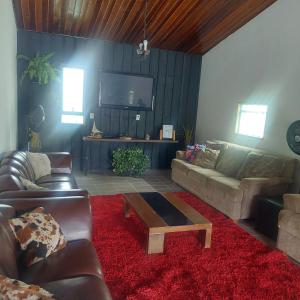 een woonkamer met banken en een salontafel bij Chácara Recanto do Sol in Mogi das Cruzes