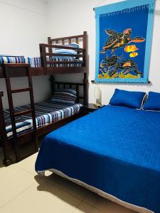 1 Schlafzimmer mit einem blauen Bett und 2 Etagenbetten in der Unterkunft CasaLu in Puntarenas