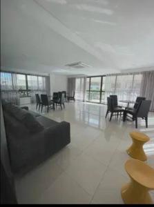 sala de estar con sofá, mesas y sillas en Apartamento Total Vista do Mar., en Salvador