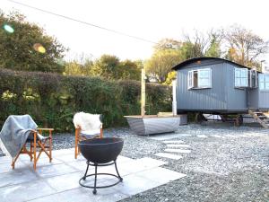 a backyard with a tiny house and some chairs at Phoebes Folly-uk36581 in Milton Abbot